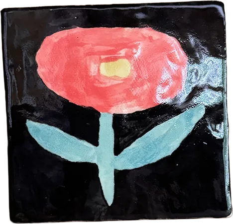 Glossy black tile painted with a coral pink flower on a pale green stem.